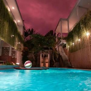 a swimming pool with a ball in front of a building at Mojosurf Camp Canggu in Canggu