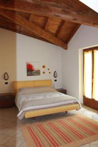 a bed in a bedroom with a wooden ceiling at Villetta Nembra in Edolo