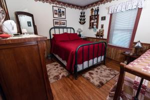 a bedroom with a bed with a red blanket at Wolf Creek Farm B&B and Motorcycle Manor at Wolf Creek Farm in Ararat