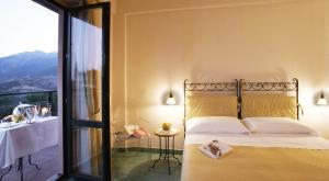 a bedroom with a bed and a table and a window at Villa Maiella in Guardiagrele
