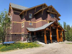 a large wooden house with a fence in front of it at Timberline by FantasticStay in Fernie