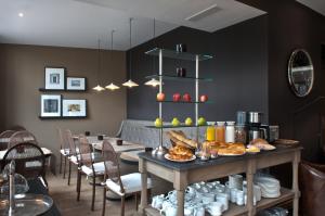 a dining room with a table with food on it at Hotel Les Terres Blanches in Chatou