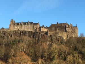 un château au sommet d'une colline rocheuse dans l'établissement Old Police House Causewayhead Stirling, à Stirling