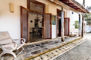 um alpendre de uma casa com uma cadeira e uma mesa em Small House Boutique Guest House em Galle