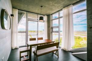 a dining room with a table and chairs and windows at Wudai in Zhuangwei