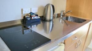 a kitchen counter with a sink and a dishwasher at Sunset Motel in Fox Glacier