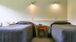 a hotel room with two beds and a table at Sunset Motel in Fox Glacier