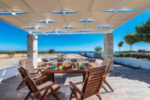 a patio with a table and chairs and the beach at Gennadi Villa Mary in Gennadi
