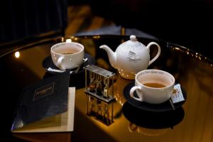 two cups of tea and a teapot on a table at Dansaert Hotel in Brussels