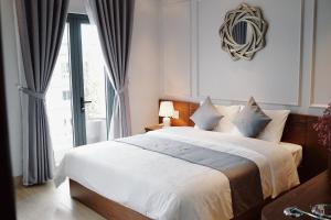 sypialnia z łóżkiem i dużym oknem w obiekcie The Confetti hotel w Ha Long
