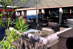 eine Terrasse mit einem Sofa, Stühlen und Tischen in der Unterkunft Boutique Hotel Kronenhof in Zürich