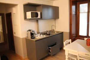 una pequeña cocina con fregadero y microondas en Residence Kalipè en Alagna Valsesia