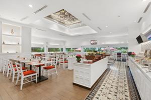 a restaurant with white counters and tables and chairs at Ascott Jakarta in Jakarta