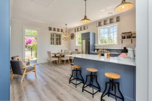a kitchen and living room with a counter and stools at Deloraine Stone Cottage in Whangarei