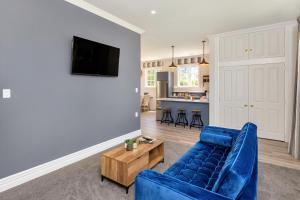 a living room with a blue couch and a table at Deloraine Stone Cottage in Whangarei