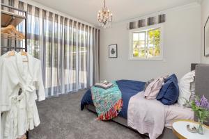 un dormitorio con una cama y una ventana en Deloraine Stone Cottage, en Whangarei 38 fotos más