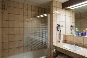 uma casa de banho com uma cabina de duche em vidro e um lavatório. em Hotel Goya em Zaragoza