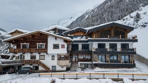 a large building with a snow covered mountain at A CASA Rubin Chalet & Studio Resort in Sölden
