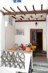 um pátio exterior com uma pérgola e uma mesa em Aleka's Rooms em Tinos Town