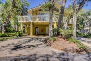a yellow house with a balcony on top of it at Alexander Beach House in Hilton Head Island