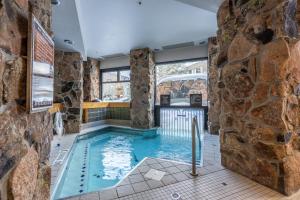 a pool in a room with a stone wall at Shoshone 1993 in Big Sky