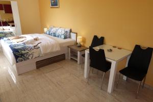 寧的住宿－Apartments Leon Nin，卧室配有一张床和一张桌子及椅子
