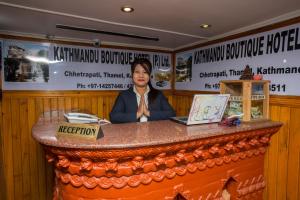 a woman sitting at a counter in a restaurant at Kathmandu Boutique Hotel in Kathmandu