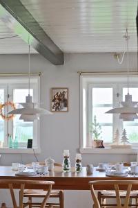 a dining room with a table and two windows at Bakkehuset Countryhouse in Skovby +111 photos