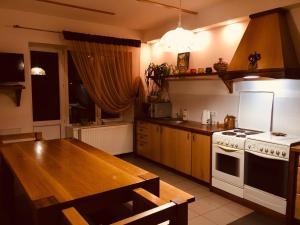 een keuken met een tafel en een fornuis top oven bij Візерунок in Dilyatyn