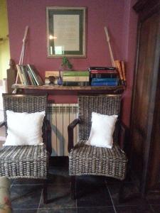 two wicker chairs with white pillows in a room at Apartamentos Rurales Buenamadre in Pola de Somiedo