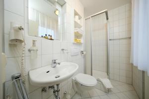 a white bathroom with a sink and a toilet at Gästehaus Schumm in Murrhardt