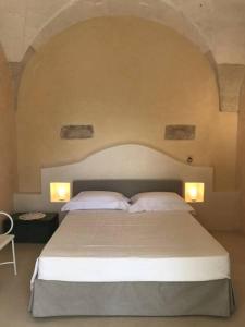 1 dormitorio con 1 cama grande y 2 almohadas blancas en Tenuta Castelle, en Cutrofiano