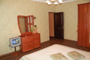 a bedroom with a tv on a dresser and a mirror at Ugodessa Apartments in Odesa