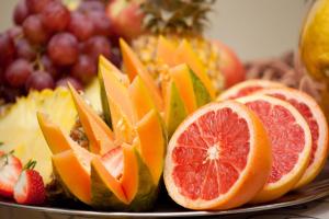 a plate of fruit with oranges and other fruits at Hotel Osner in East London