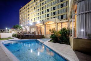a swimming pool in front of a building at night at Hotel Osner in East London