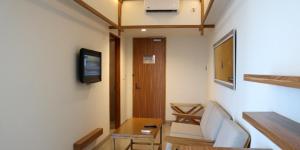 a room with a hallway with a table and a television at ILLIRA Hotel Banyuwangi in Banyuwangi