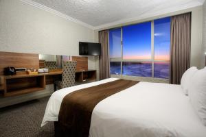 a hotel room with a bed and a desk and a window at Hotel Osner in East London