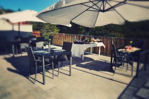 a patio with tables and chairs and an umbrella at AMICI Holiday B&B di Bielak Aneta Izabela in Vezzano Ligure