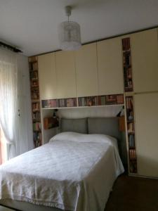 a bedroom with a white bed and book shelves at B&B Metrò in Bussero