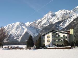 a building in front of a snow covered mountain at Adlerhof am Sonnenplateau in Mieming