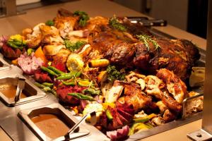 a tray of meat and vegetables on a table at Hotel Osner in East London