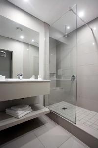 a bathroom with a glass shower and a sink at Hotel Osner in East London