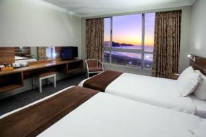 a hotel room with two beds and a large window at Hotel Osner in East London