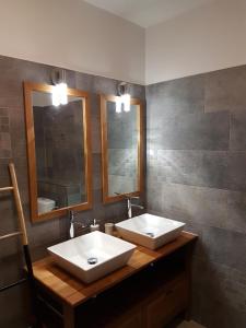 a bathroom with two sinks and two mirrors at LE BELVÉDÈRE in LʼEntre-Deux