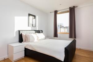 um quarto com uma cama grande e uma janela em East Croydon Apartments - Just 3 mins walk to East Croydon station em Croydon