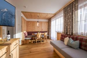 uma sala de estar com um sofá e uma mesa em Appartementhaus Adlerblick em Mayrhofen