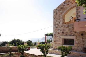 a house with a stone wall and a fireplace at Romantica Apartments in Falasarna