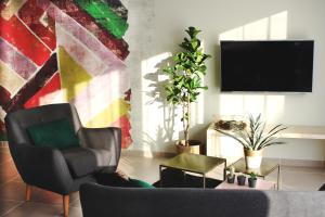 a living room with a chair and a flat screen tv at Clos de la Couturelle in Millonfosse
