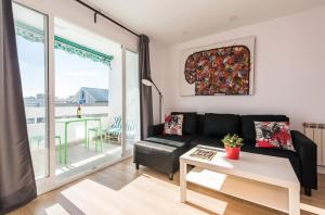 a living room with a couch and a large window at Ever House IFEMA Mar de Cristal in Madrid