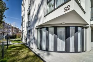 - un bâtiment blanc avec de grandes fenêtres sur le côté dans l'établissement LTC Apartments Ujejskiego, à Gdynia